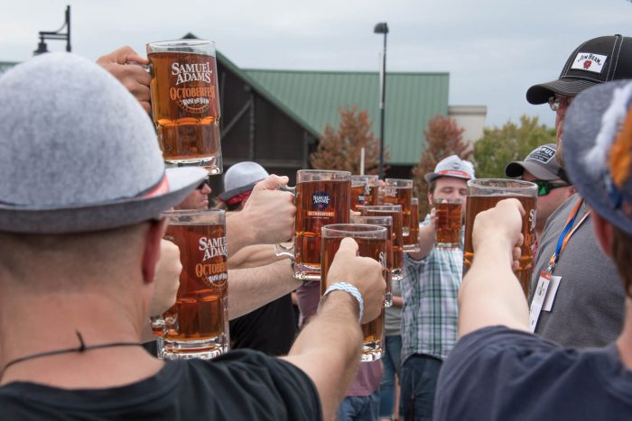 Group of men raising beer glasses to toast.